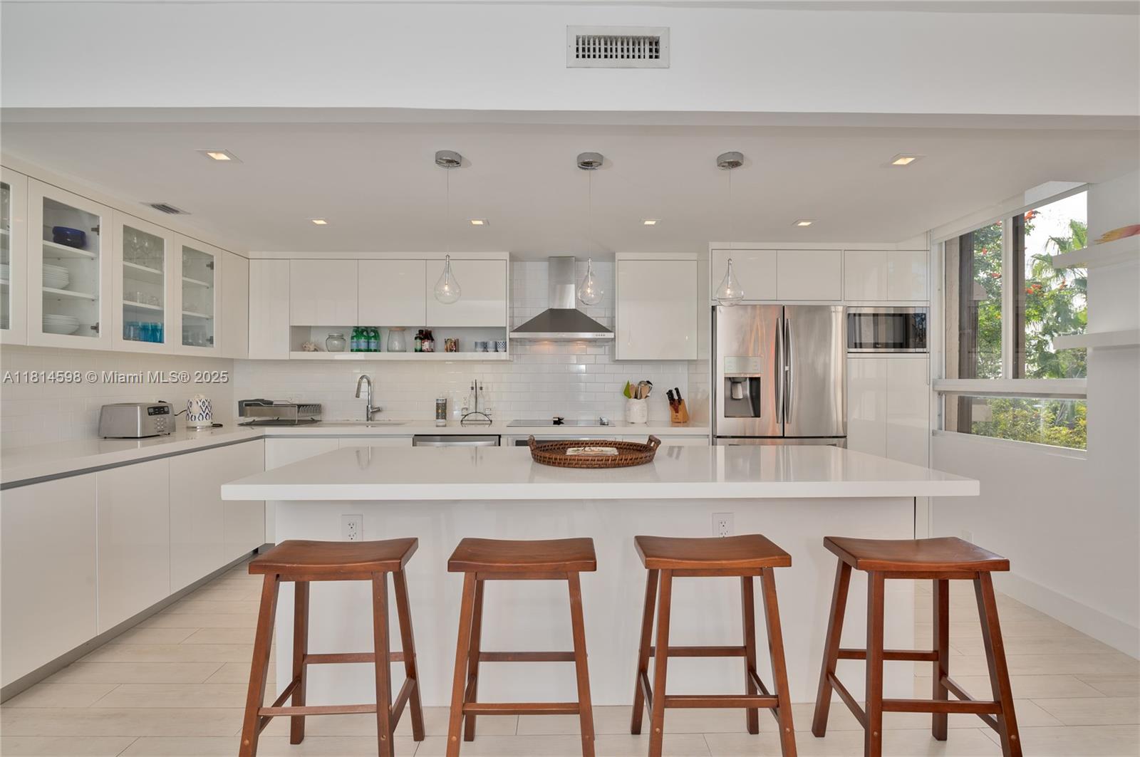 101 Crandon Boulevard, Unit 480 Key Biscayne, FL 33149 - Photo 7 of 28 a kitchen with stainless steel appliances granite countertop a table chairs sink and cabinets