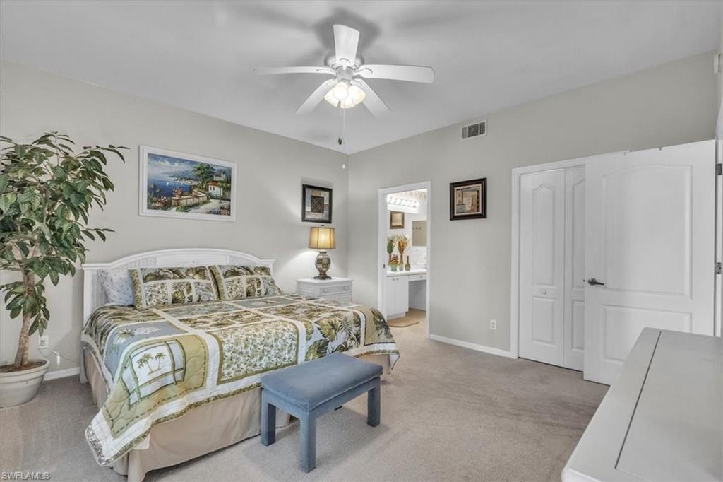 8075 Tiger Cove, Unit 1706 Naples, FL 34113 - Photo 17 of 50 Bedroom featuring light carpet, a ceiling fan, and ensuite bath