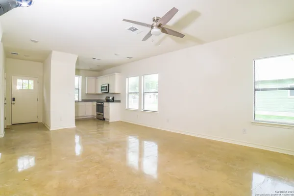 a view of a kitchen with a stove cabinets a ceiling fan and wooden floor