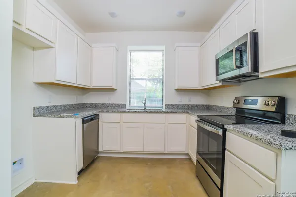 a kitchen with stainless steel appliances granite countertop a stove a sink and a microwave