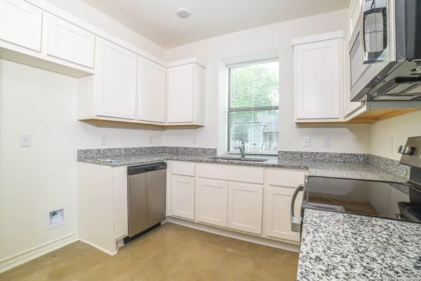 a kitchen with granite countertop a sink and a stove