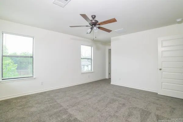 an empty room with a window and a fan