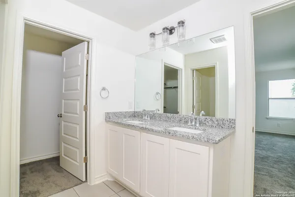 a bathroom with a granite countertop sink and a mirror