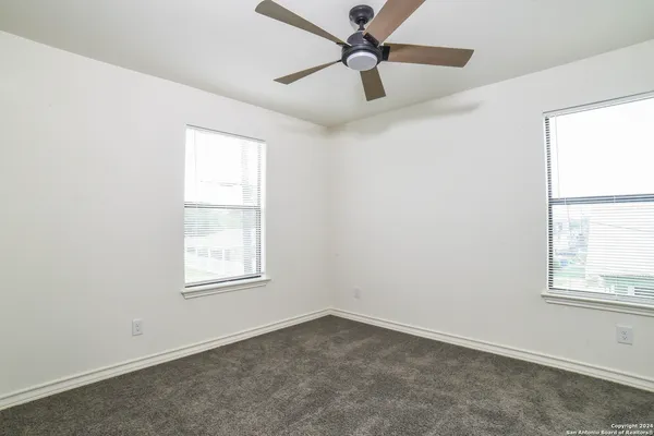 an empty room with a window and a fan
