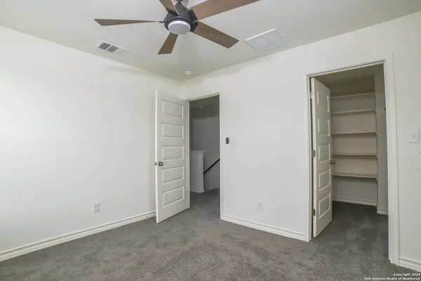 a view of an empty room and a ceiling fan