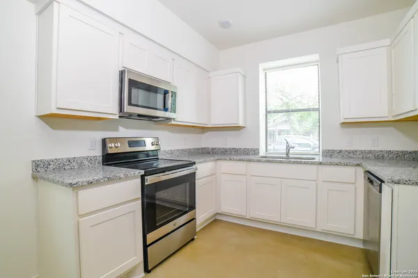 a kitchen with stainless steel appliances granite countertop a stove a sink and a microwave