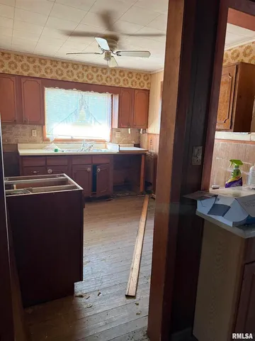 a kitchen with stainless steel appliances granite countertop a refrigerator a sink dishwasher a stove and white countertops with wooden floor