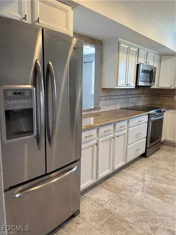 a view of a refrigerator in kitchen and entryway
