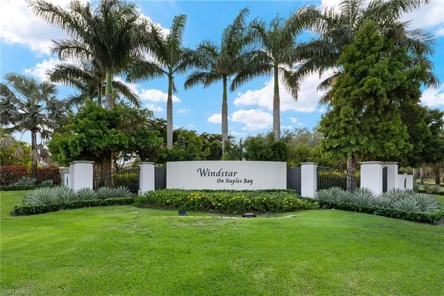 a view of a house with a big yard and palm trees