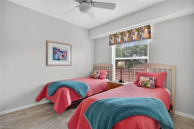 a bedroom with two beds and a painting on the wall