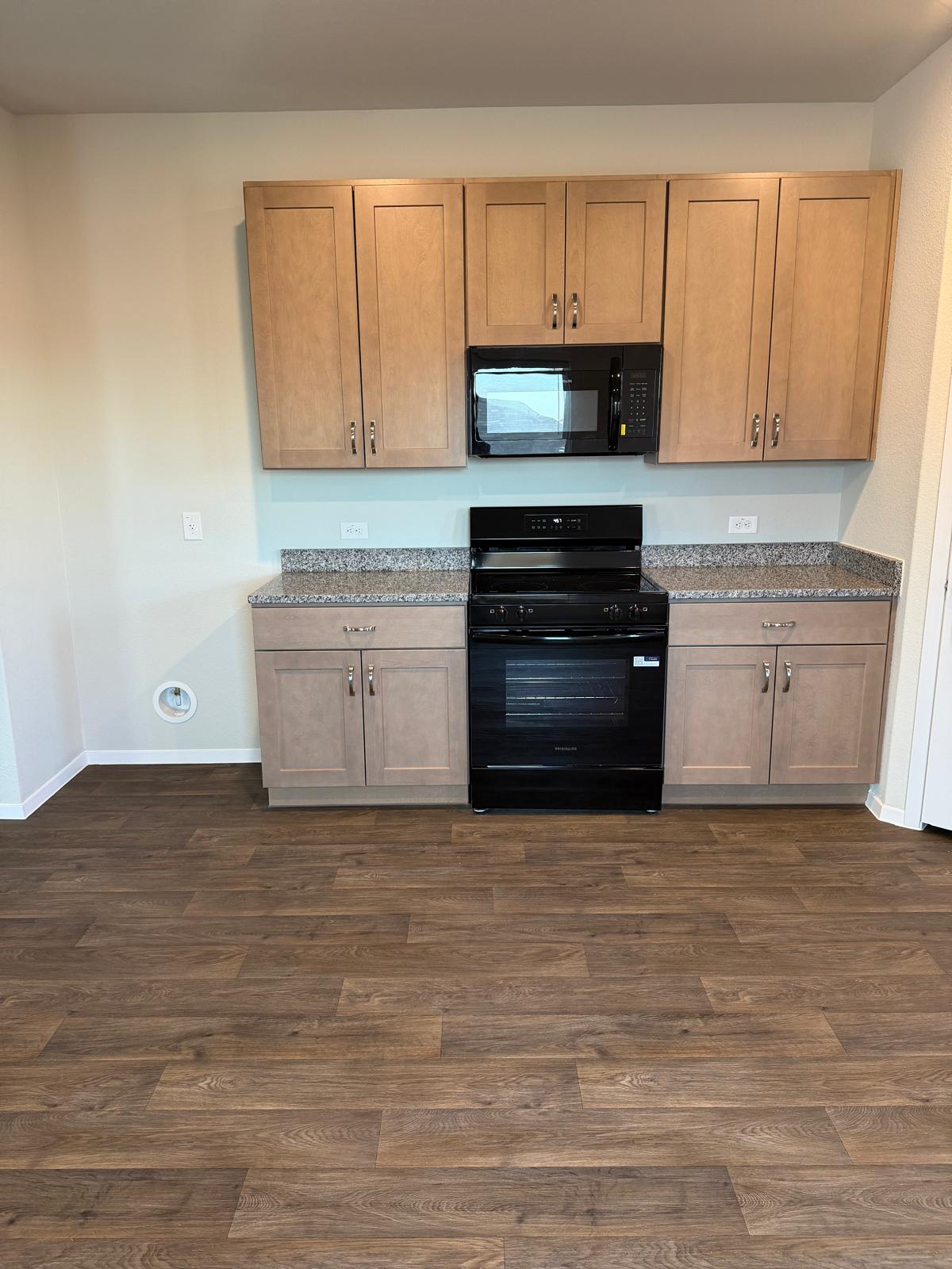 2708 Towy Road Pflugerville, TX 78660 - Photo 11 of 34 a kitchen with granite countertop a stove a sink and a microwave