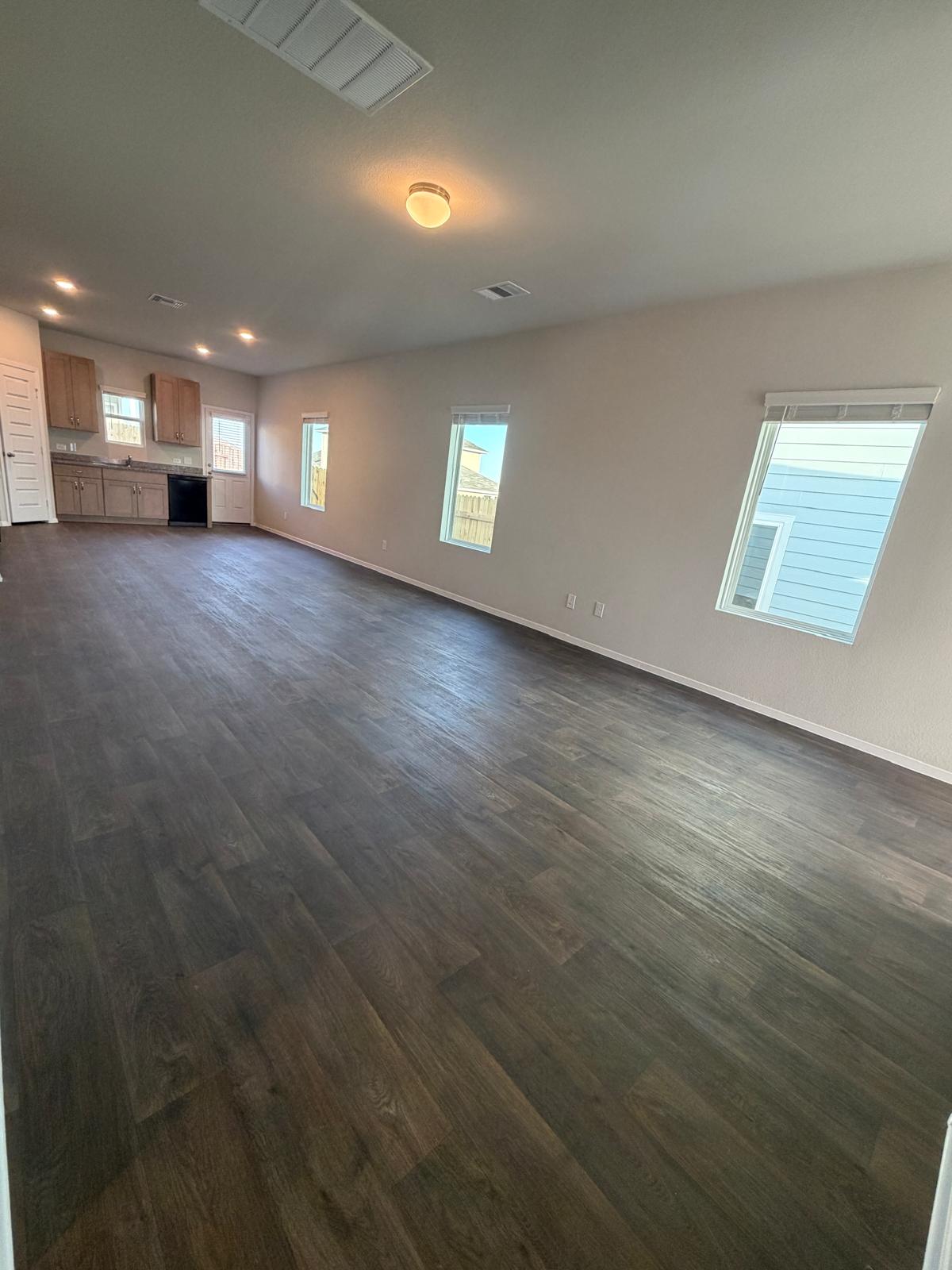 2708 Towy Road Pflugerville, TX 78660 - Photo 8 of 34 an empty room with wooden floor and windows