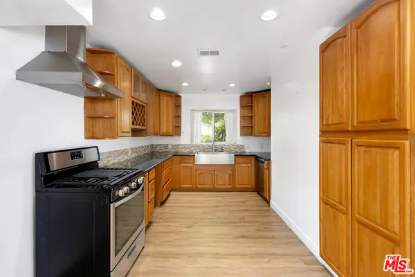 a large kitchen with stainless steel appliances granite countertop a stove and a refrigerator