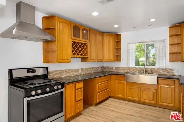 a kitchen with stainless steel appliances granite countertop a stove a sink and a granite counter tops