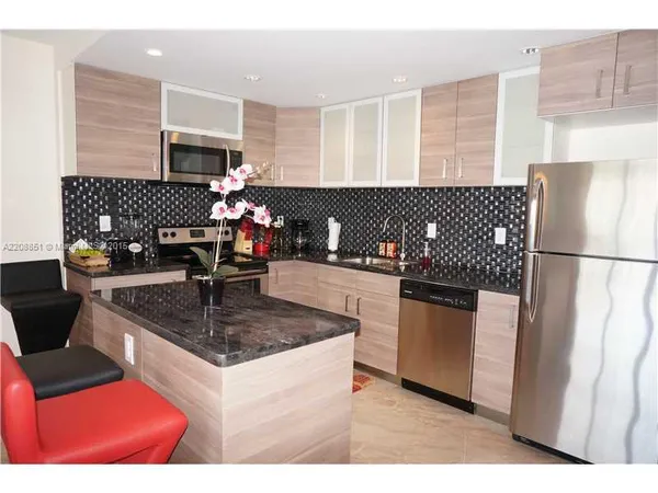 a kitchen with stainless steel appliances granite countertop a sink dishwasher stove and refrigerator