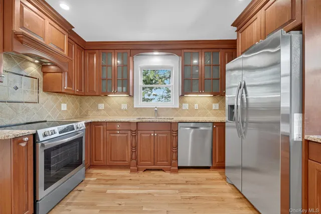 a kitchen with stainless steel appliances granite countertop a refrigerator and a stove