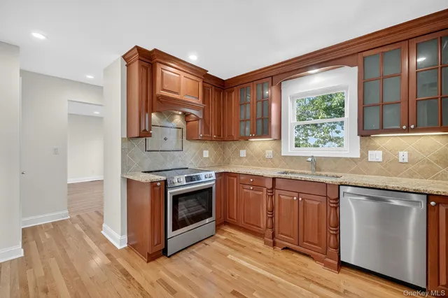 a kitchen with stainless steel appliances granite countertop a stove a sink and a microwave