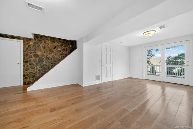 a view of an empty room with a fireplace and a window
