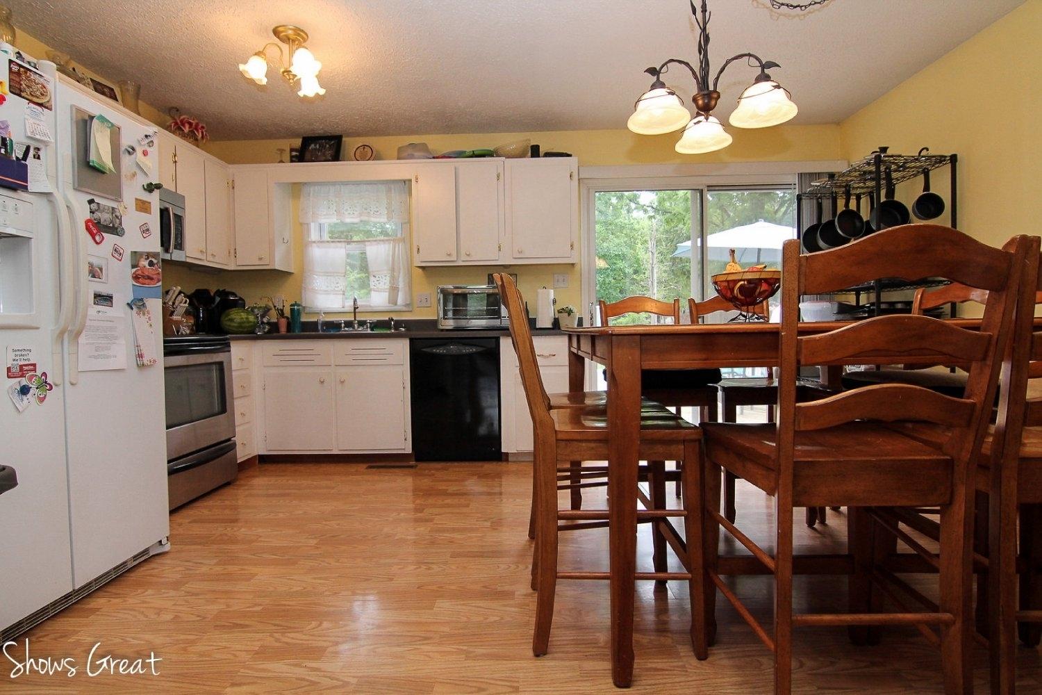 2973 Old Forge Road Callaway, VA 24067 - Photo 8 of 22 a kitchen with stainless steel appliances granite countertop a stove a refrigerator a microwave a dining table and chairs with wooden floor