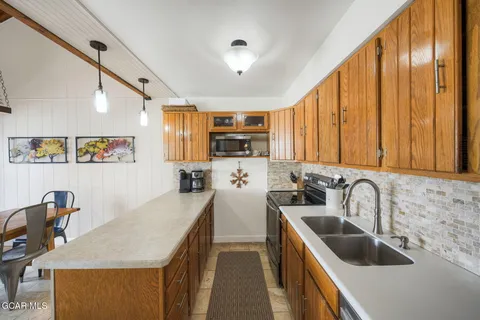 a kitchen with stainless steel appliances a sink a stove and a refrigerator