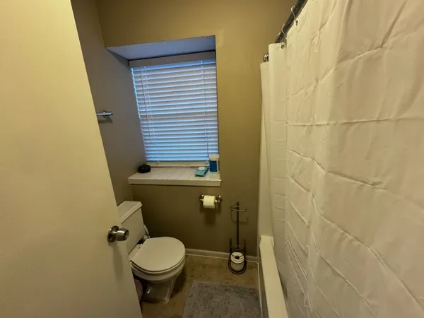 a bathroom with a toilet and a shower