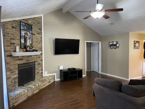 a living room with furniture a fireplace and a flat screen tv