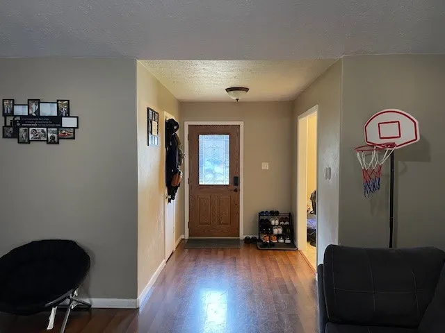 a view of a hallway with wooden floor and furniture