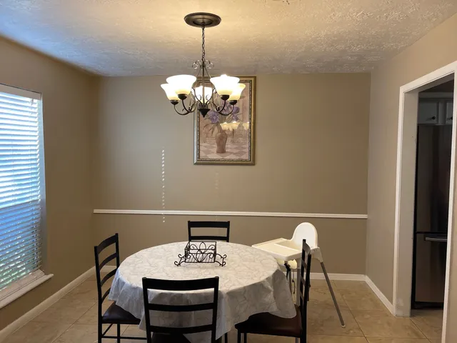 a view of a dining room with a table and chairs