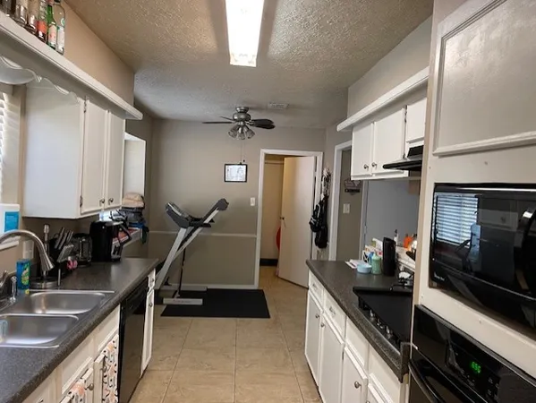 a kitchen with a sink appliances and cabinets
