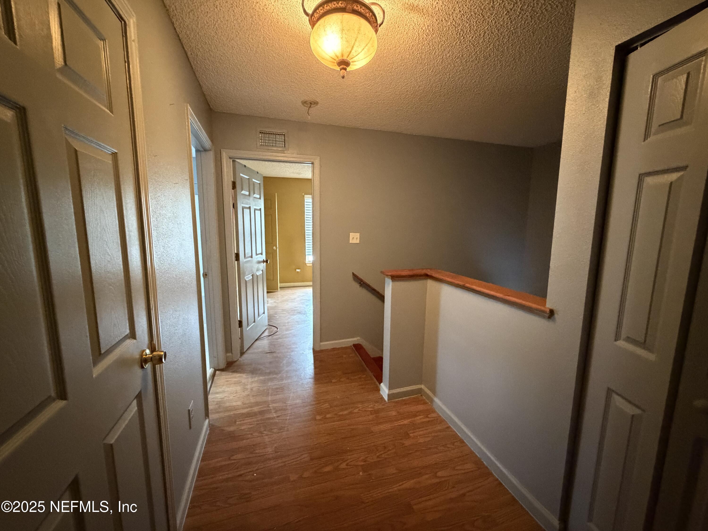 1114 Scheidel Court Atlantic Beach, FL 32233 - Photo 6 of 13 a view of a hallway with wooden floor and staircase
