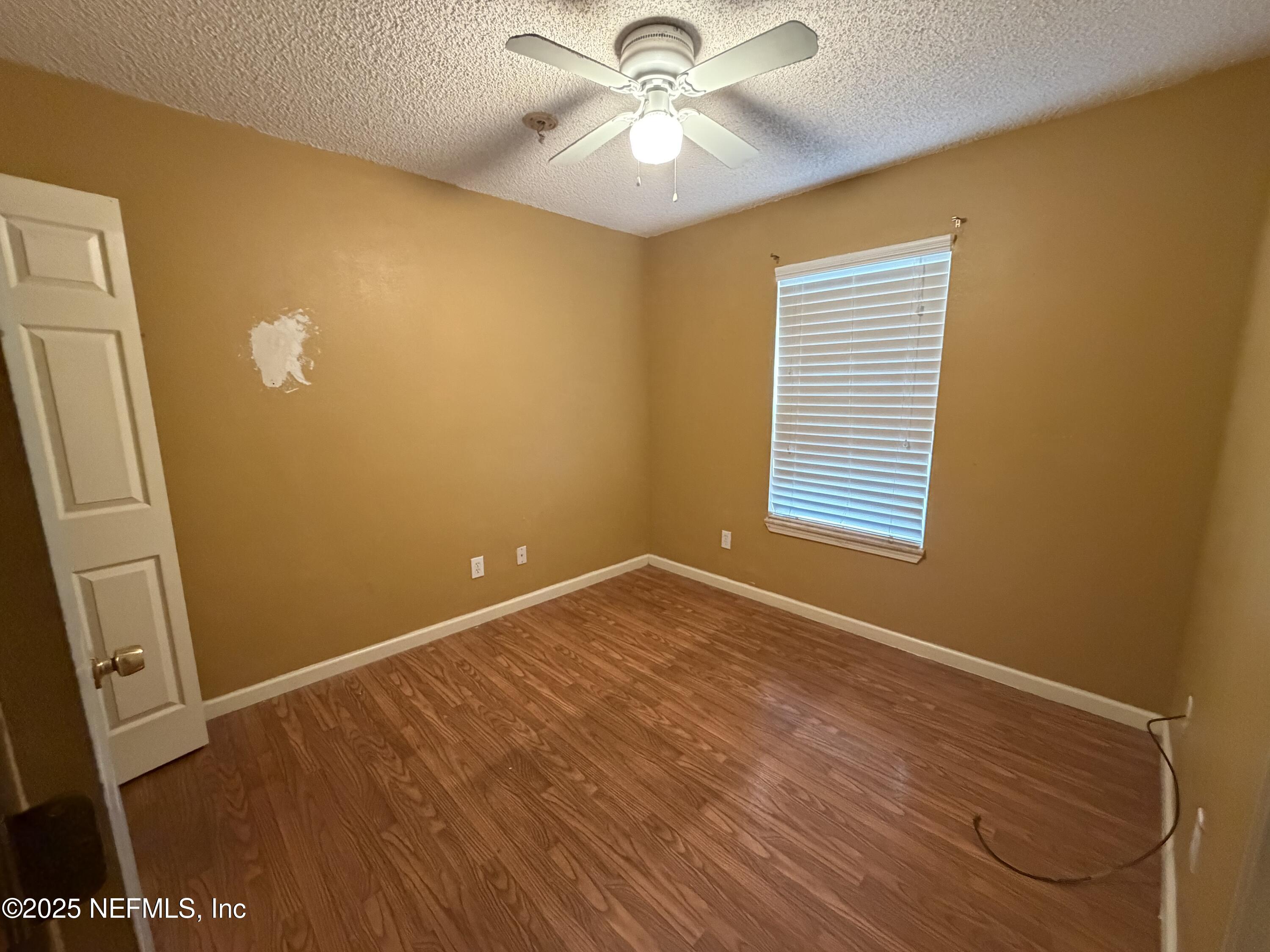 1114 Scheidel Court Atlantic Beach, FL 32233 - Photo 8 of 13 a view of an empty room with window and wooden floor