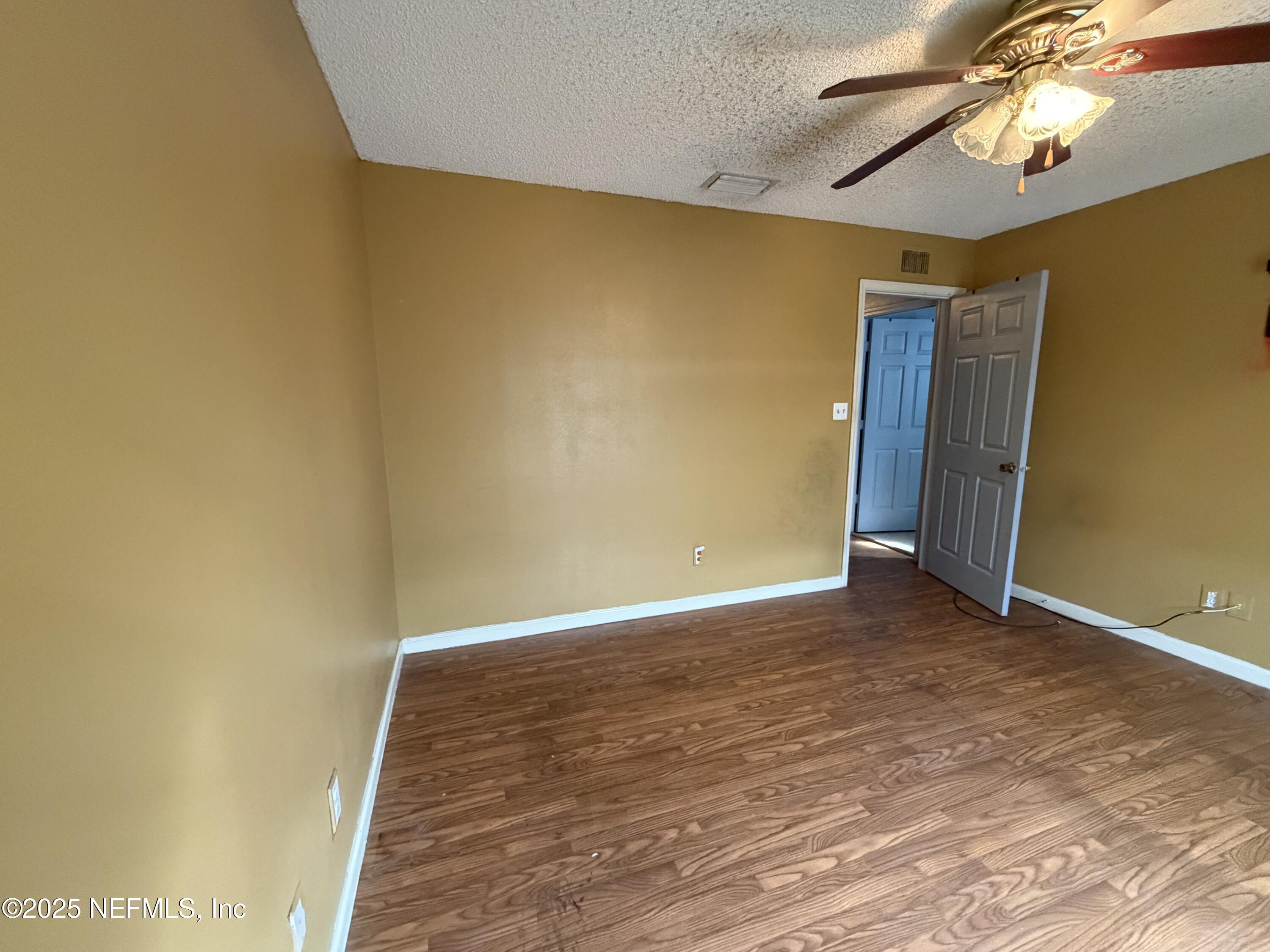 1114 Scheidel Court Atlantic Beach, FL 32233 - Photo 9 of 13 a view of room with wooden floor and ceiling fan