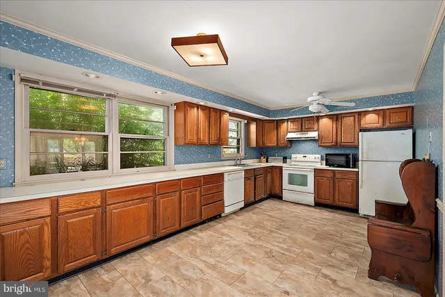a kitchen with stainless steel appliances granite countertop a sink dishwasher stove and refrigerator