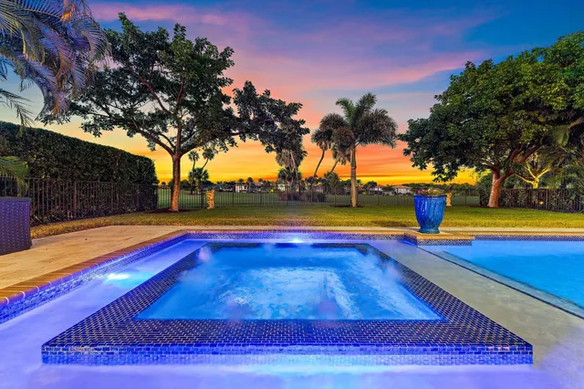 a view of a white house with a yard and potted plants