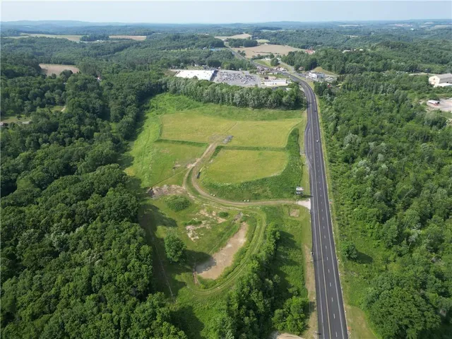 an aerial view of residential houses with outdoor space and trees