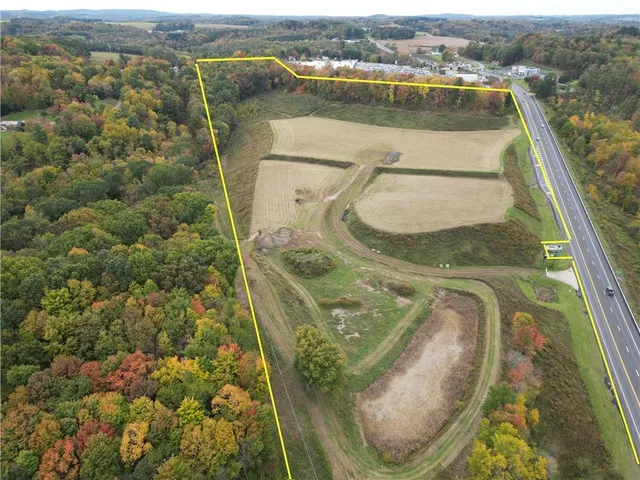 an aerial view of a house with a yard and mountain view