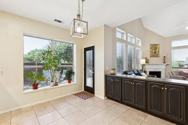 a view of a kitchen with kitchen island granite countertop a refrigerator stove top oven and sink