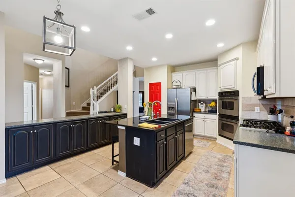 a kitchen with lots of counter top space appliances and cabinets