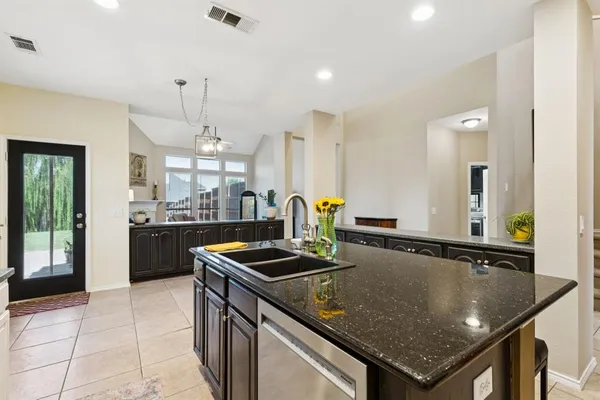 a kitchen that has a sink a counter top space and stainless steel appliances