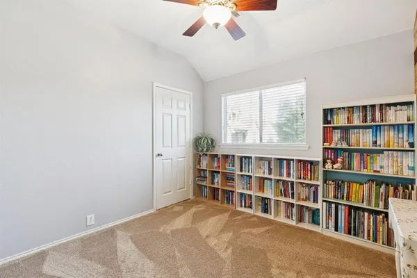 a view of room with windows book shelves