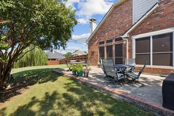 a view of backyard with table and chairs and wooden fence