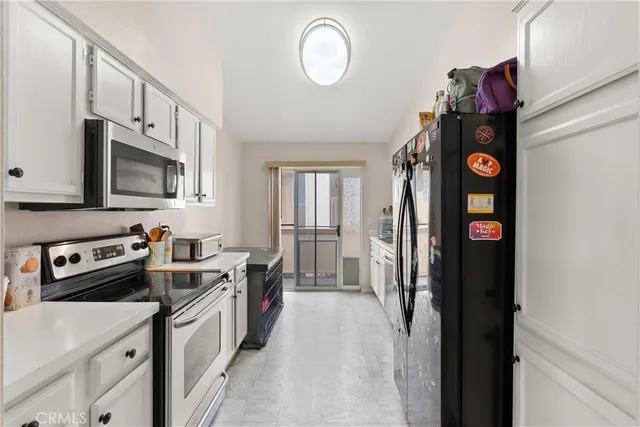 a kitchen with stainless steel appliances granite countertop a refrigerator a stove top oven a sink and dishwasher