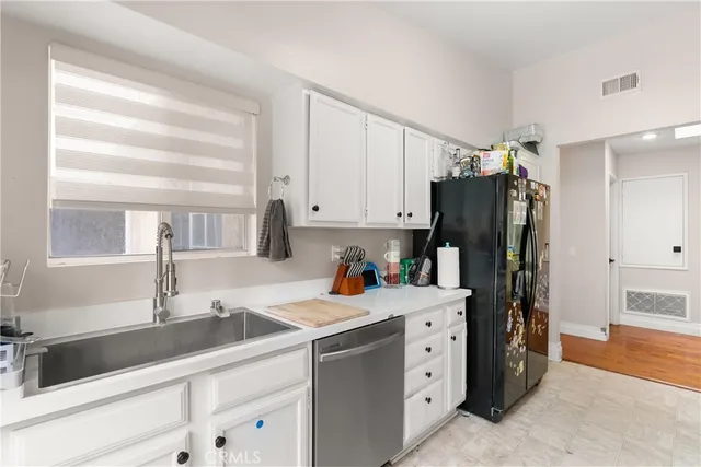 a kitchen with appliances a sink and cabinets