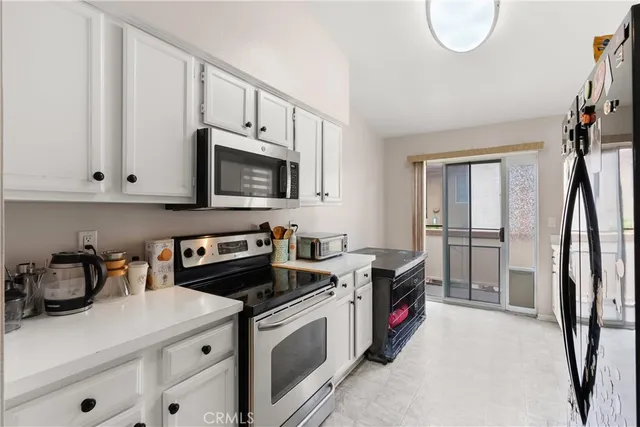 a kitchen with stainless steel appliances granite countertop a stove a sink and a white cabinets