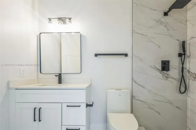 a bathroom with a sink vanity mirror and toilet