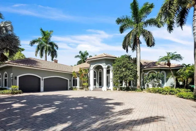 a front view of a house with yard and palm tree