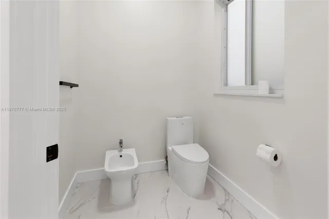 a white toilet sitting next to a bathroom sink