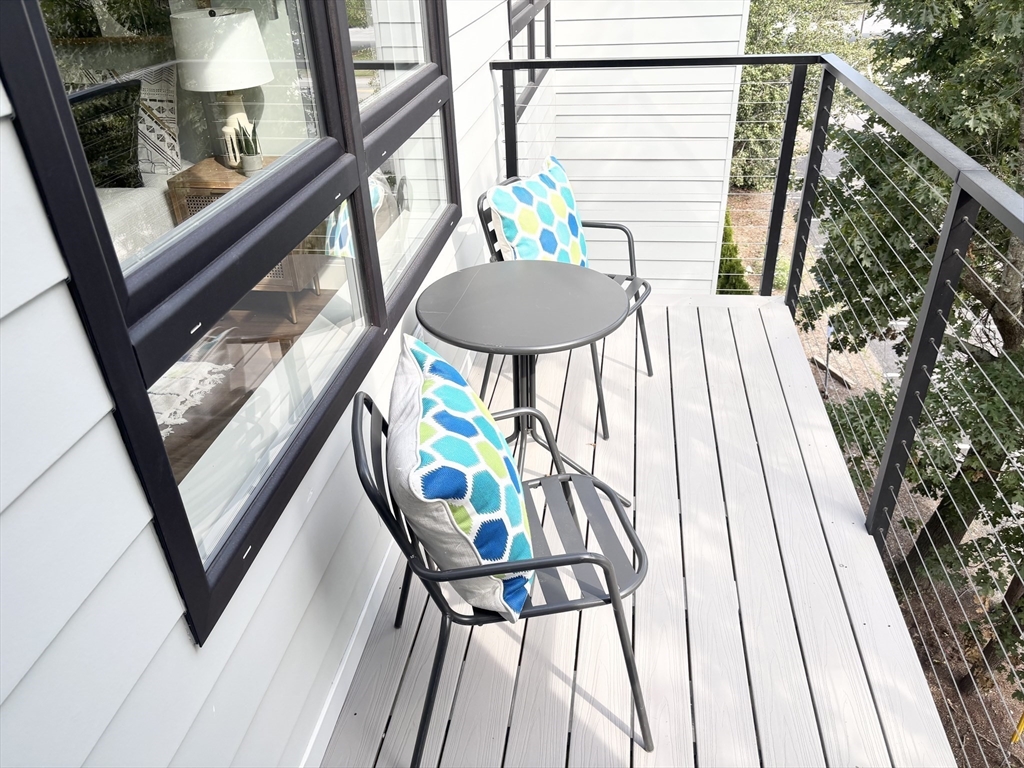 1391 Main Street, Unit 202 Walpole, MA 02081 - Photo 27 of 34 a balcony with wooden floor and furniture