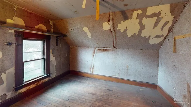 a bed sitting in a bedroom next to a window