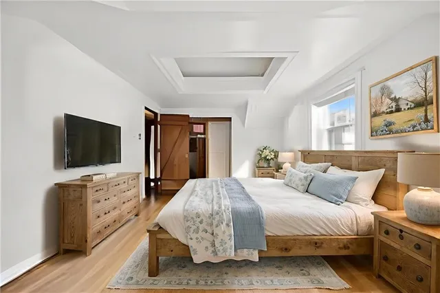 a bedroom with a bed and wooden floor